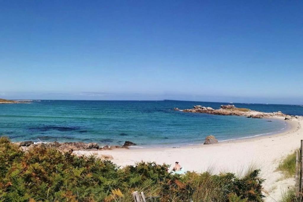 Quelques personnes se promenant sur une plage dans l'établissement Grande maison dans un village côtier du Finistère, à Guissény
