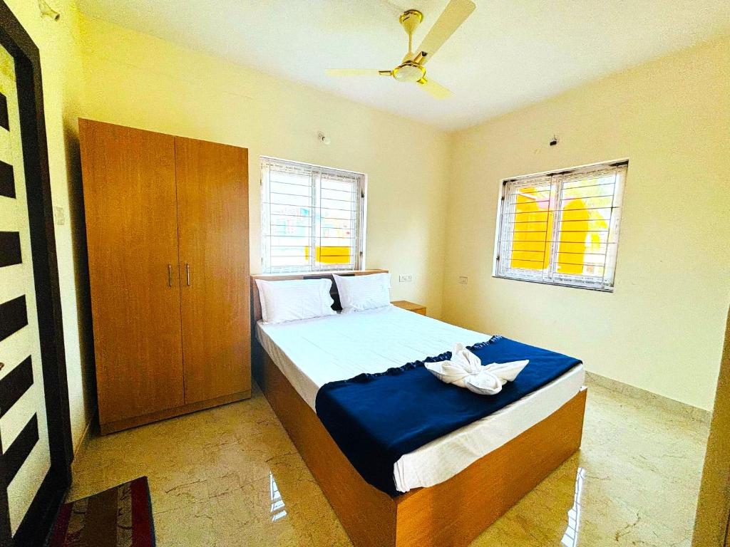 a bedroom with a large bed with a blue blanket at Hotel Golden Homes Inn Puri in Puri