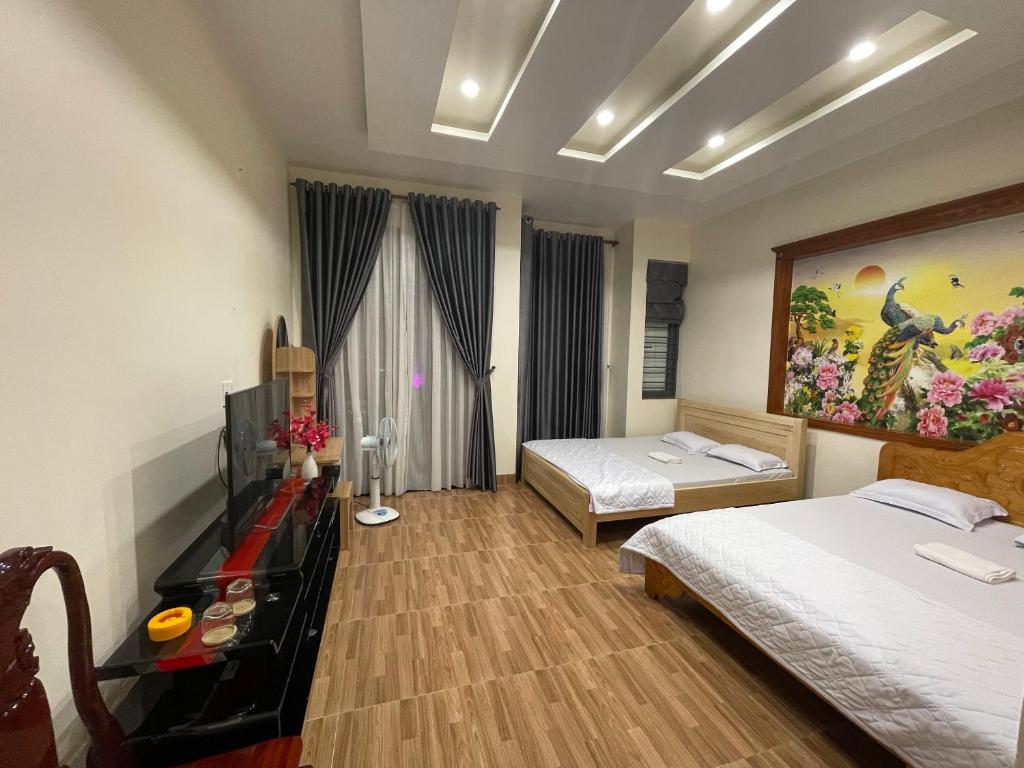 a bedroom with two beds and a painting on the wall at Hà Linh Motel in Vung Tau