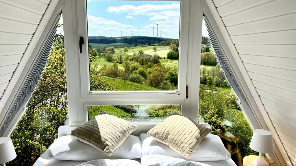 a room with a large window with a couch in front at Design Chalet Vulkaneifel in Kerschenbach