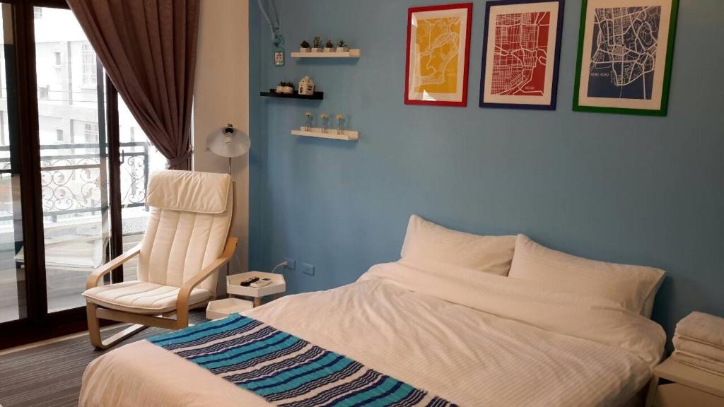 a bedroom with a bed and a chair and a window at STSP Guest House in Xinshi