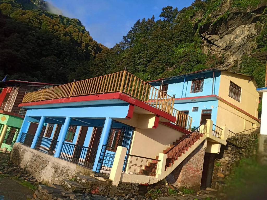 a house with a staircase in front of a mountain at King of Himalaya Homestay in Sari