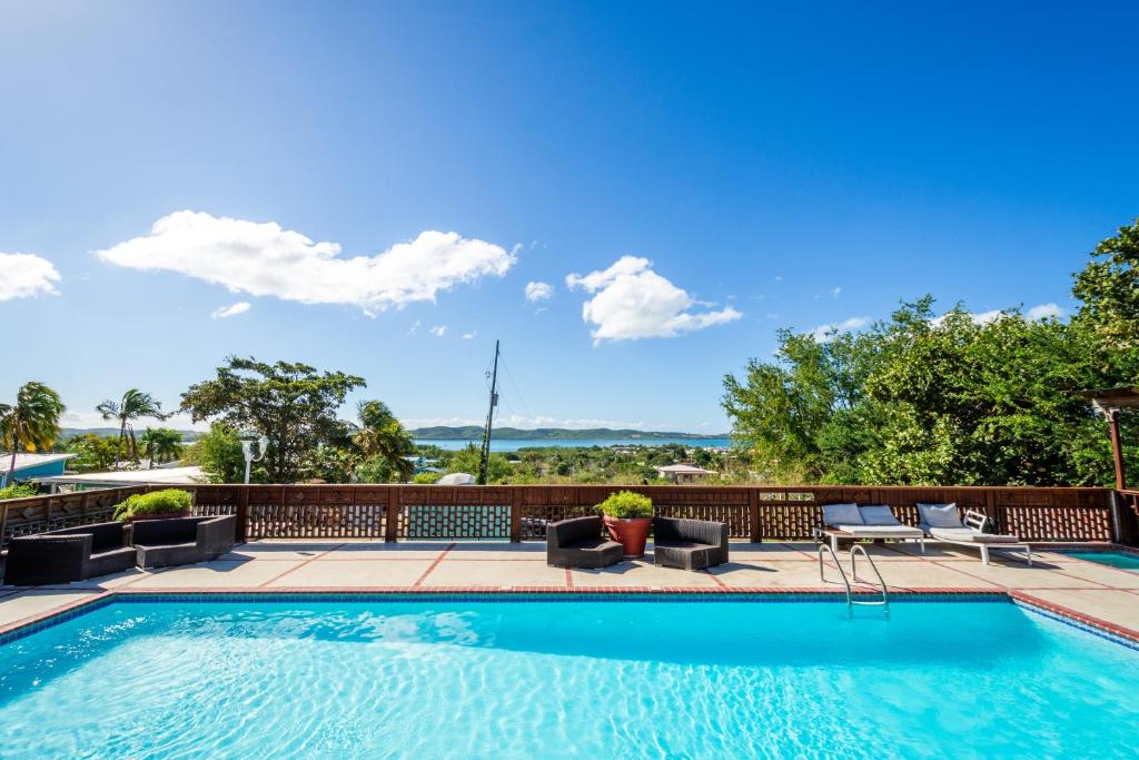 a swimming pool with patio furniture and a view at West Coast Inn's in Boqueron