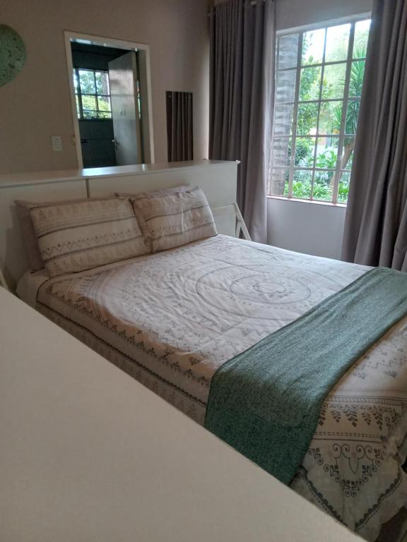 ein großes Bett in einem Schlafzimmer mit Fenster in der Unterkunft "O Sole Mio" Self catering studio apartment in Bedfordview in Bedfordview