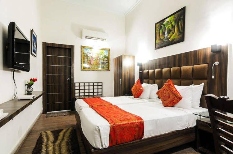 a bedroom with a large bed and a television at Hotel Superhouse by Wisdom Madhav in Mathura