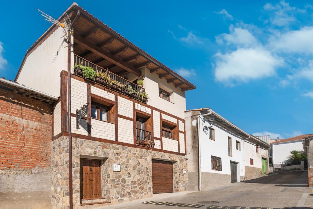 an old building with a balcony on a street at Casa Rural La Chopera del Jerte in Jerte