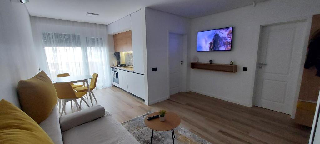uma sala de estar com um sofá e uma televisão na parede em SIA Studio em Oradea