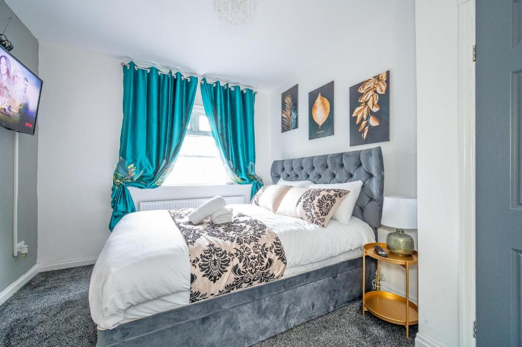 um quarto com uma cama com cortinas azuis em *RB75L* For your most relaxed & Cosy stay + Free Parking + Free Fast WiFi * em Hunslet