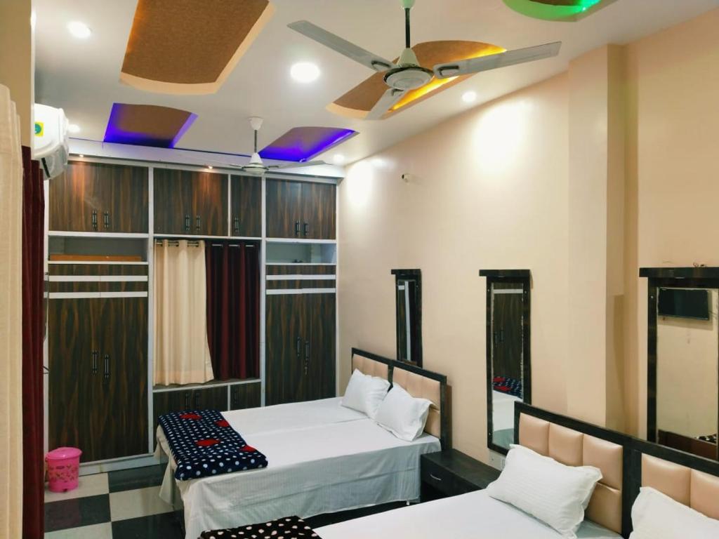 a room with two beds and a ceiling fan at Mishra Guesthouse in Varanasi
