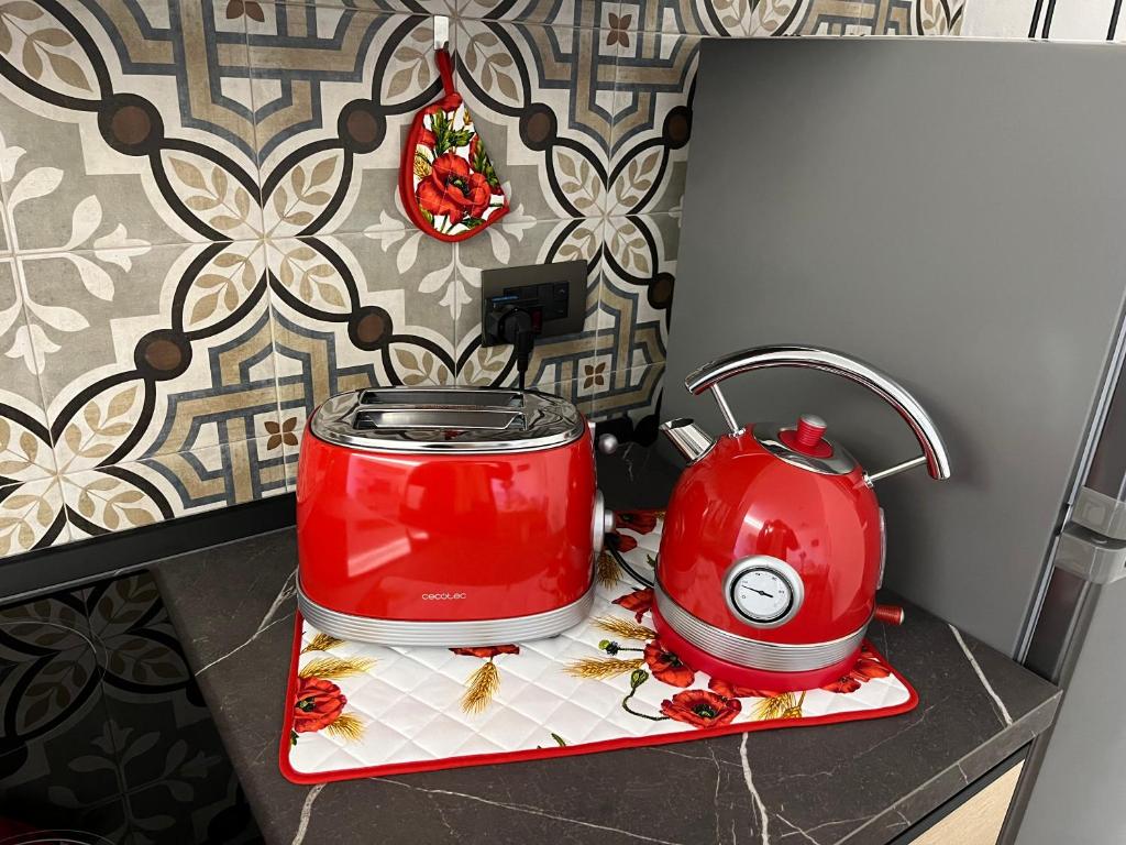 a red slow cooker and tea kettle on a counter at La Casina di Cinzia in San Gimignano