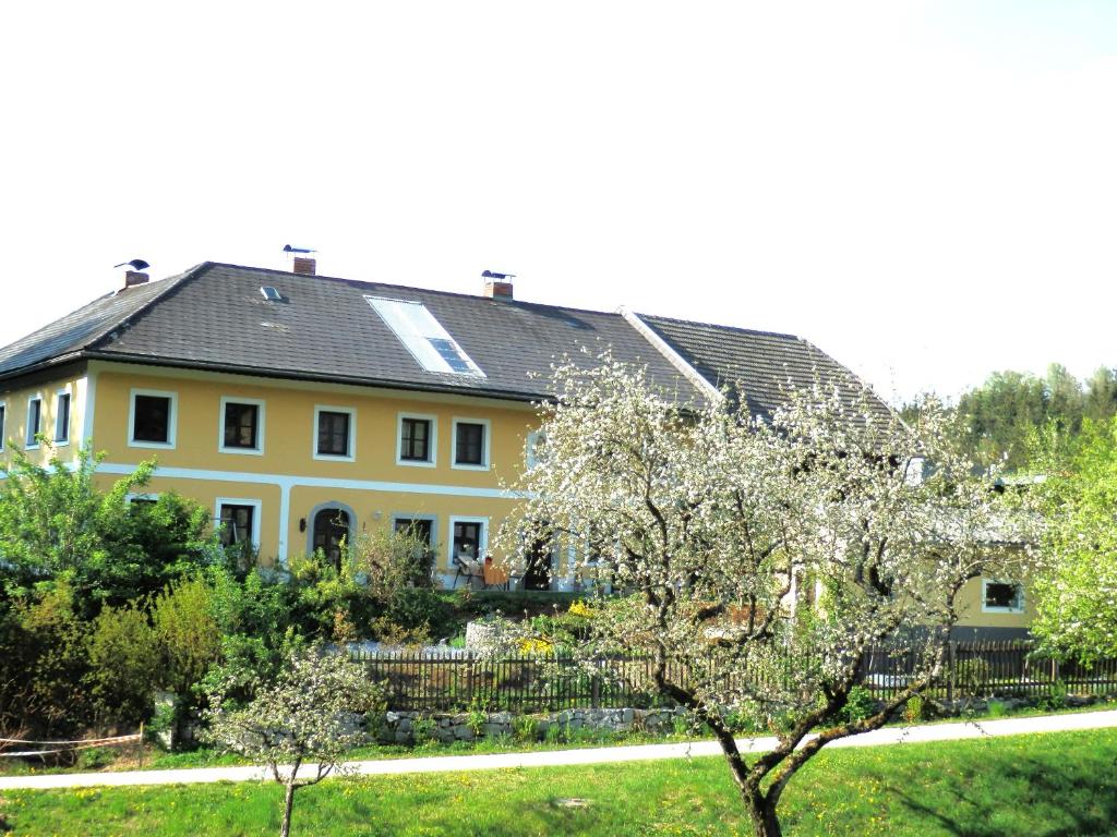 ein großes gelbes Haus mit schwarzem Dach in der Unterkunft Naturoase Mühlviertel in Sankt Johann am Wimberg