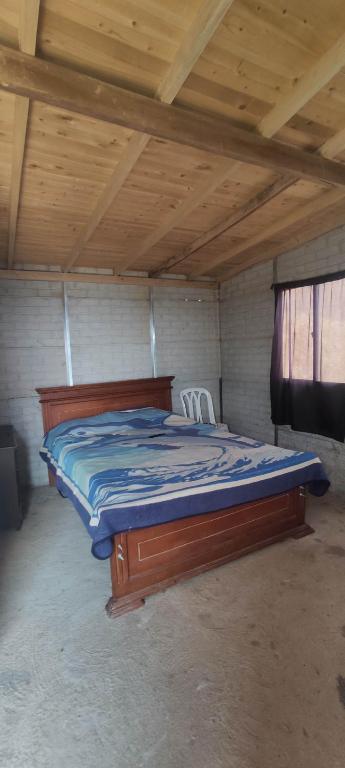a bed in a room with a wooden ceiling at La vista más linda del oriente in Guarne