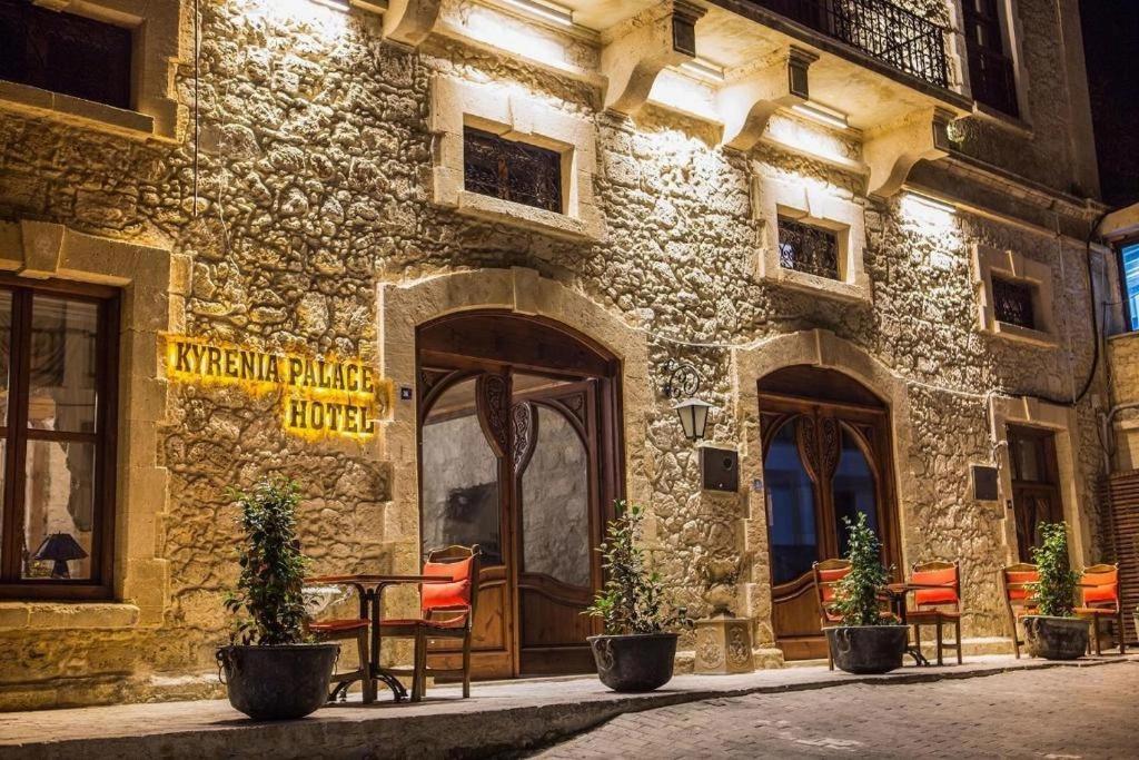 kyrenia palace boutique hotel في كيرينيا: مبنى امامه طاولة وكراسي