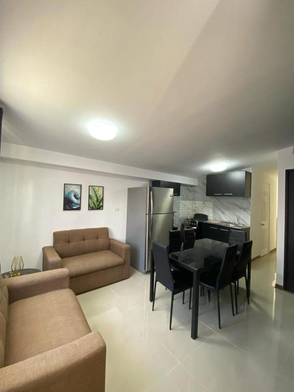 ein Wohnzimmer mit einem Sofa, einem Tisch und Stühlen in der Unterkunft Tranquilo, Central y acogedor in San José