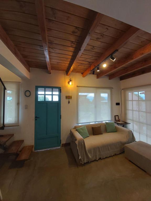 1 dormitorio con cama y puerta verde en Hospedaje Los Cardones en Cafayate