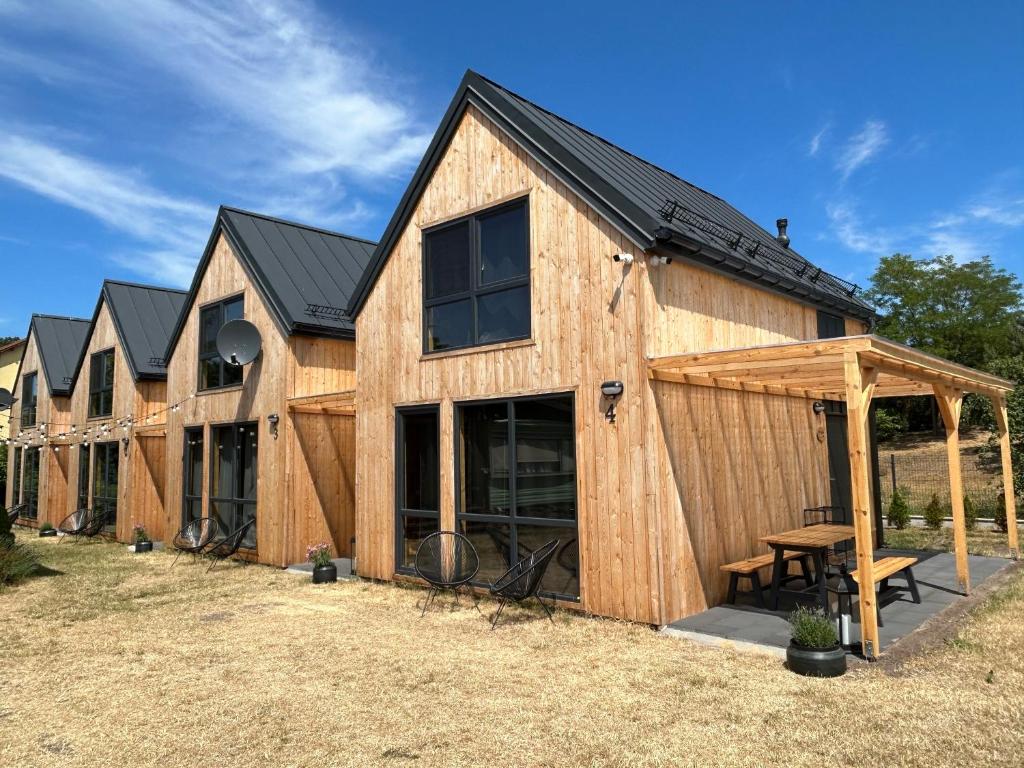 een grote houten schuur met een tafel in een tuin bij Stodoły na Mierzei in Kąty Rybackie