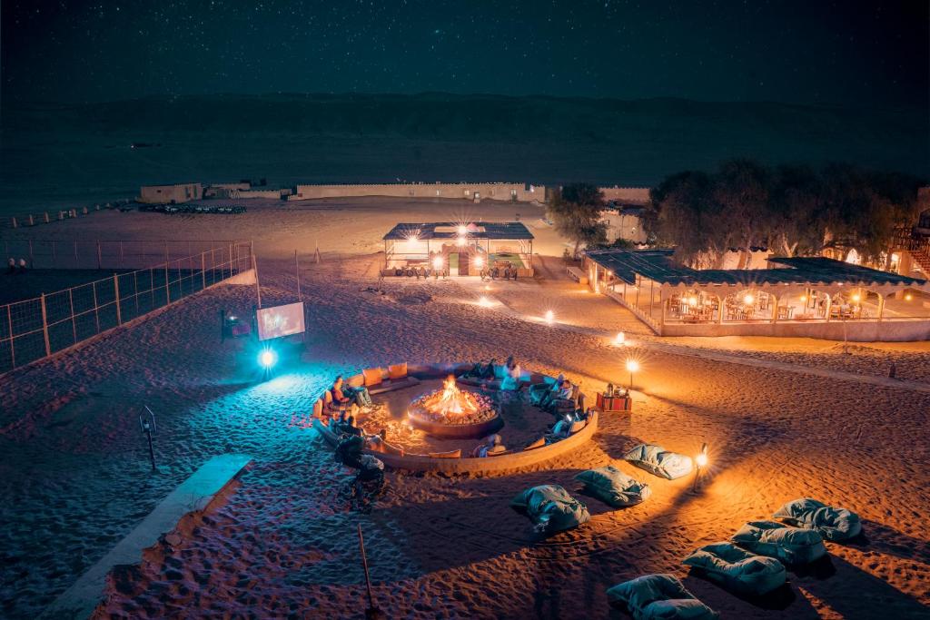 widok na plażę w nocy z oświetleniem w obiekcie Thousand Nights Camp w mieście Shāhiq