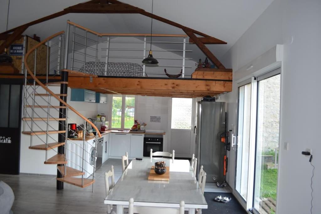 a kitchen with a dining table and a loft at Joinville : Grange entièrement rénovée style loft. in Joinville