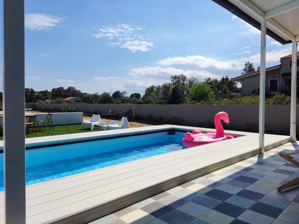 a swimming pool with a pink flamingo in a backyard at Feel like Home Villa in Schinias