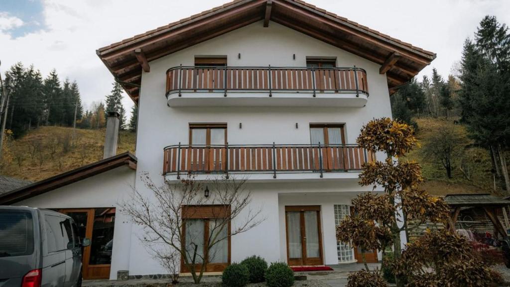 a white house with a balcony on top of it at Vila Kony in Borsa