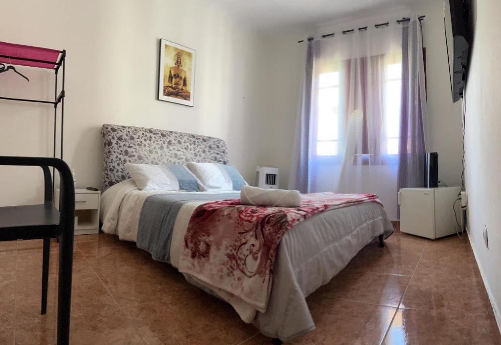 a bedroom with a bed and a window at Home JV in Getafe