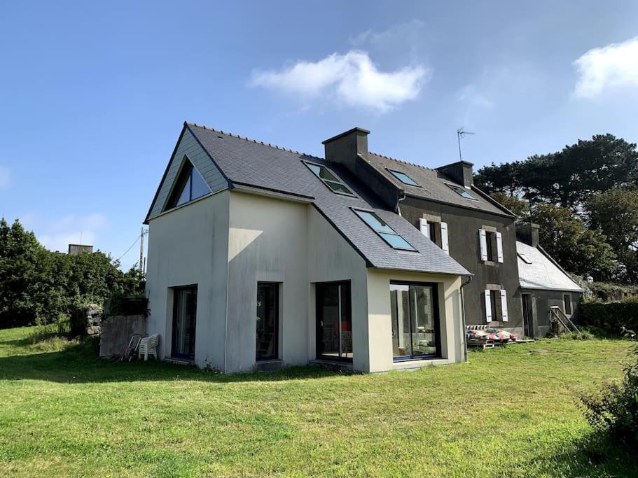 ein weißes Haus mit schwarzem Dach auf einem Hof in der Unterkunft Maison lumineuse entre mer et campagne 6 personnes in Plouguerneau