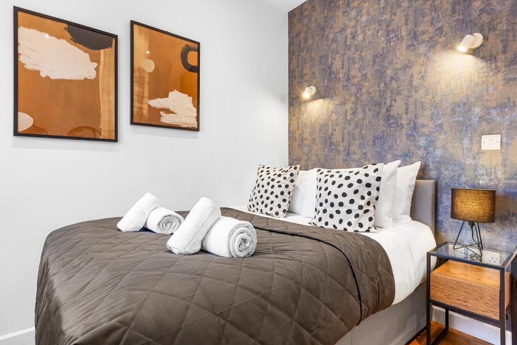 una camera da letto con un grande letto con cuscini bianchi di Modern One Bedroom Flat - Near Heathrow, Windsor Castle, Thorpe Park - Staines London TW18 a Londra