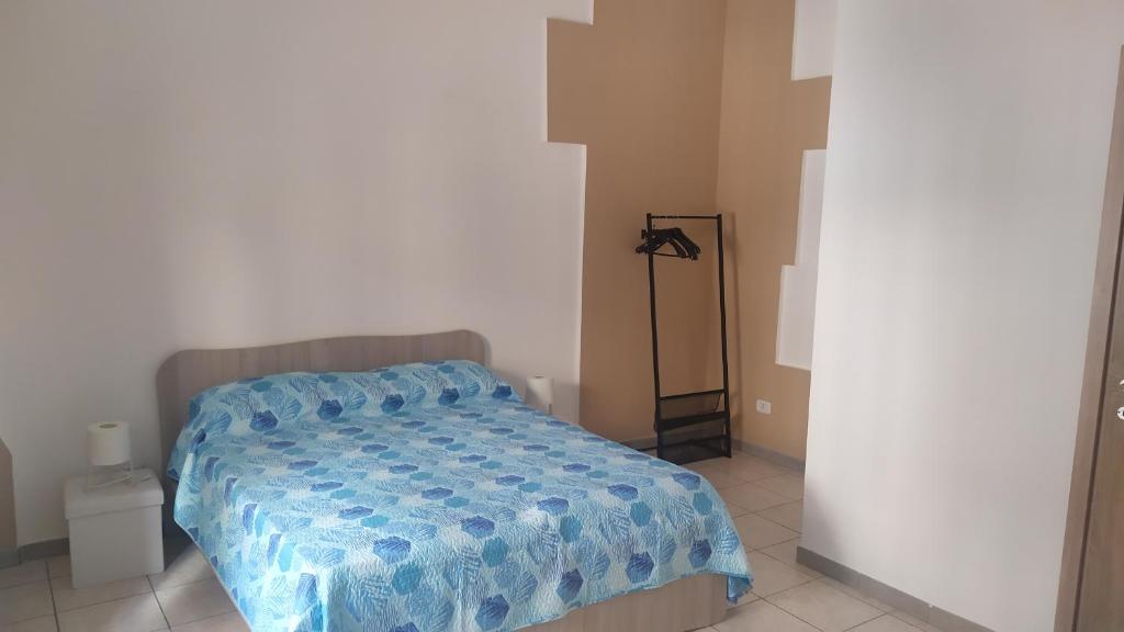 1 dormitorio con 1 cama con edredón azul en Lino's house, en Adrano