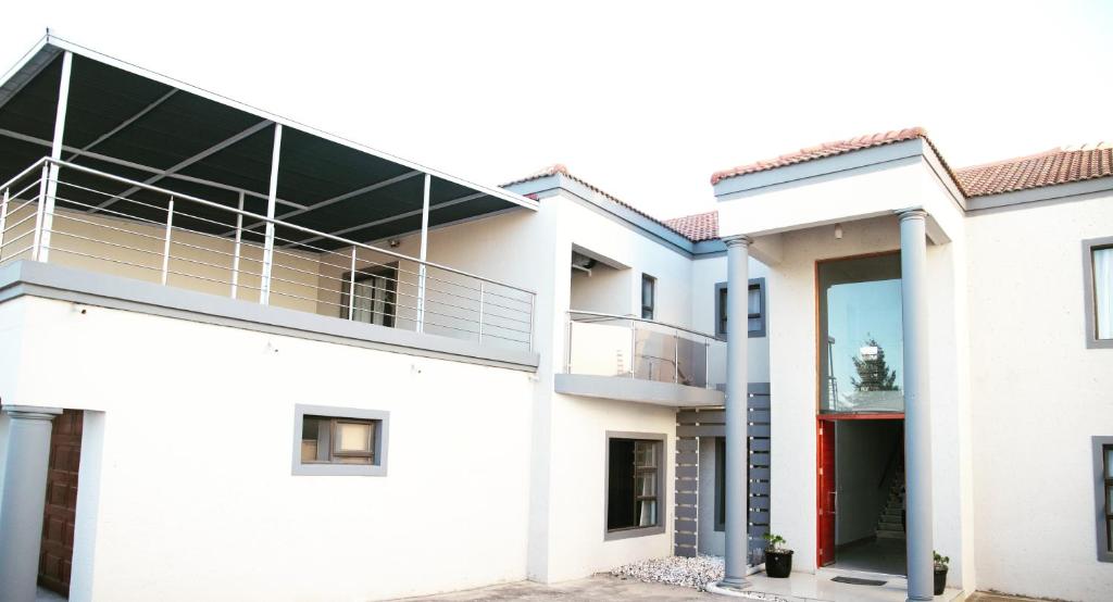 a white house with a glass roof at AZALEA LODGE in Midrand