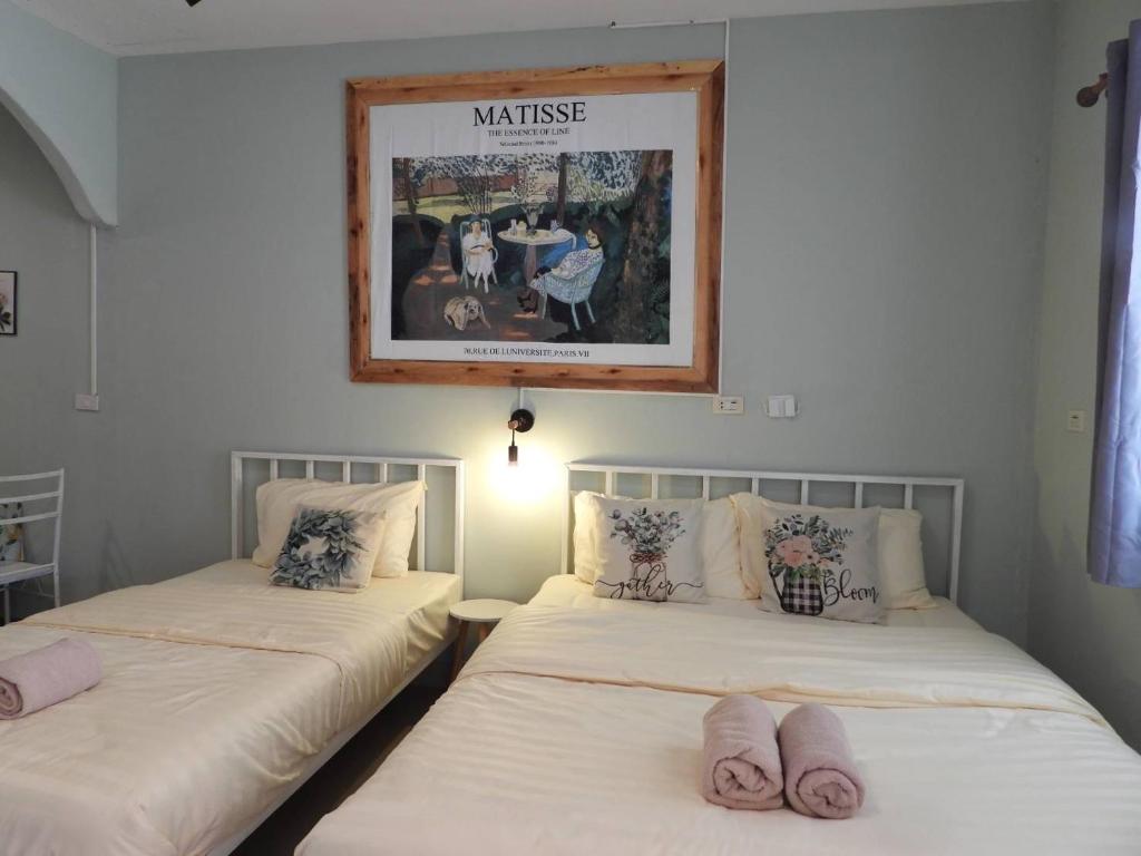 two beds in a room with a picture on the wall at 888 private room near khaoyai in Mu Si