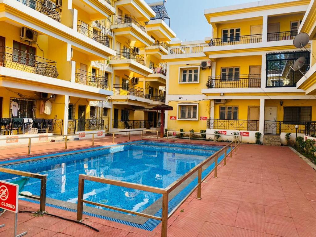 a swimming pool in front of a building at Tony's Inn Baga Apartment in Baga