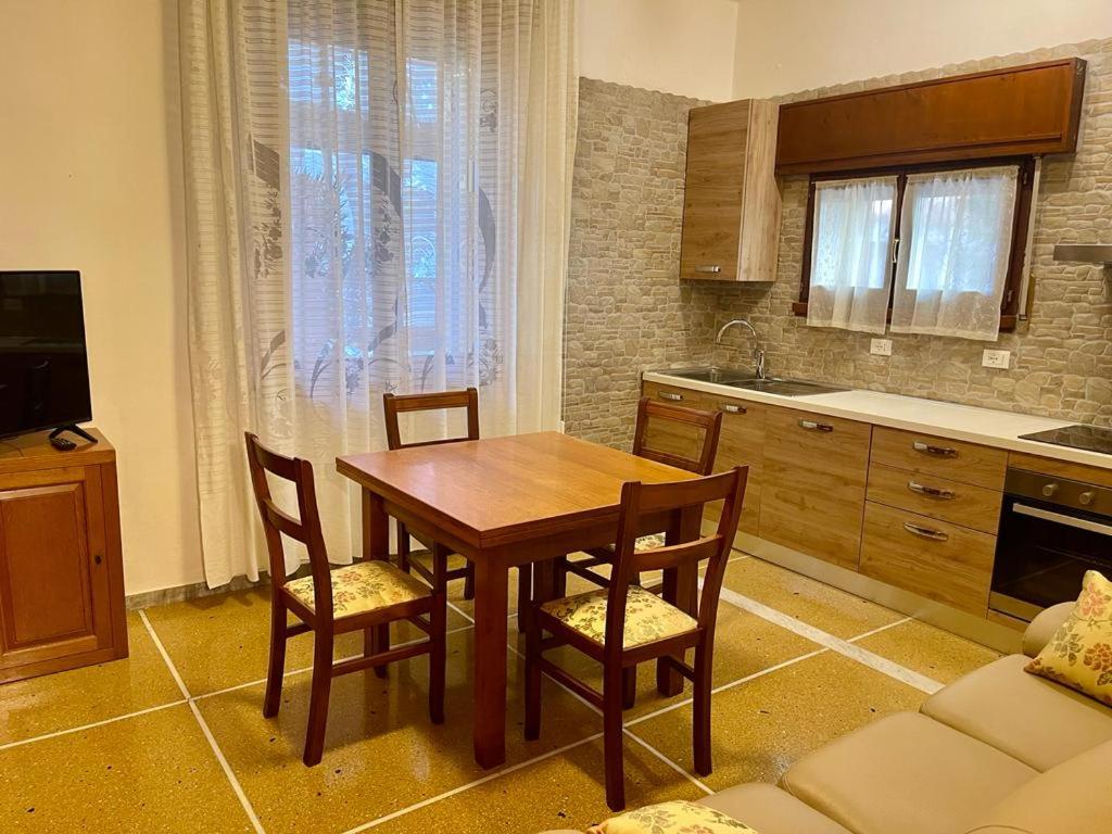 a kitchen with a wooden table and chairs in a room at Appartamento Saragozza in Bologna