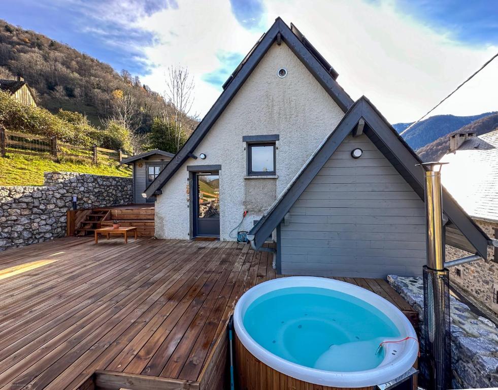 eine Badewanne auf einer Holzterrasse mit einem Haus in der Unterkunft Chalet Le René-Sens - 5 pers - Grande terrasse - bain nordique in Boutx