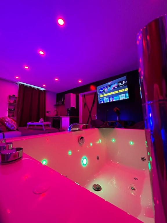 a large tub in a room with purple lights at MJ Lust Room, centre var proche Verdon, cotignac, ambiance romantique in Montfort-sur-Argens