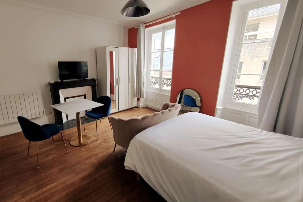 1 dormitorio con 1 cama, mesa y sillas en Terracotta Studio en Orléans