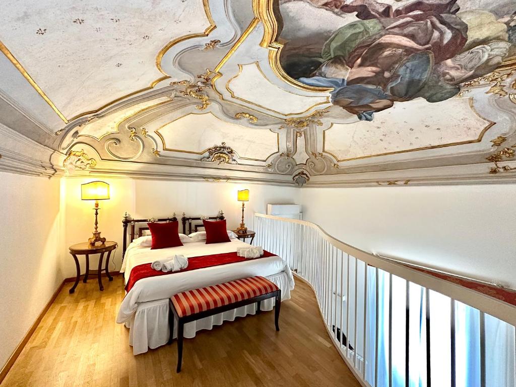 a bedroom with a ceiling with a painting at Case Natoli - Residenze d'Epoca in Palermo