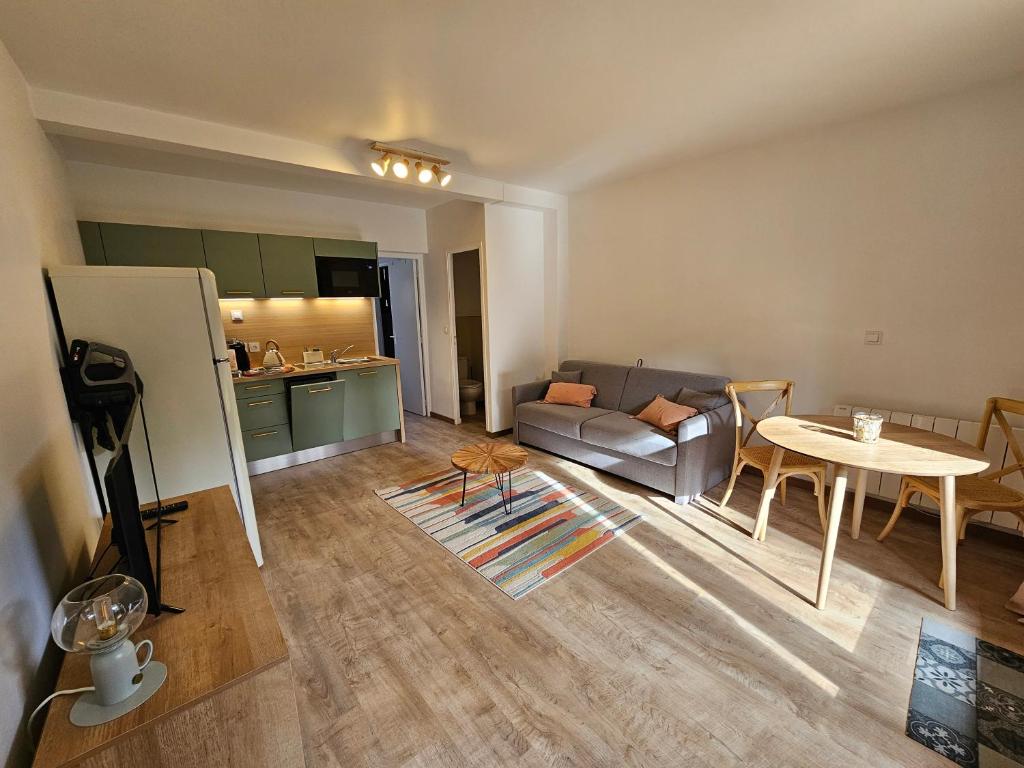 salon z kanapą i stołem w obiekcie L'annexe, Village de l'Herbe w mieście Lège-Cap-Ferret