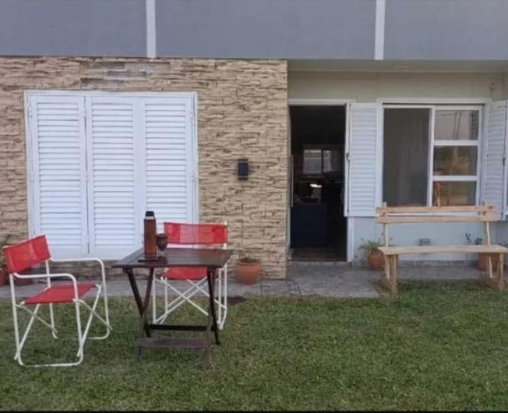 un patio con mesa, 2 sillas y un banco en LOS MELLIS en Villa Elisa