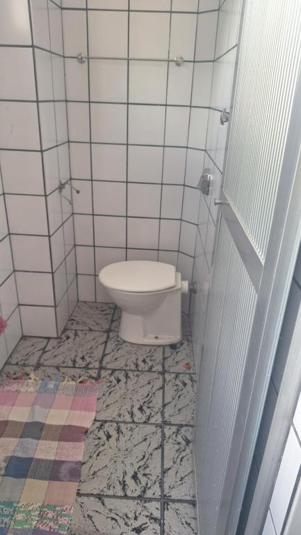 ein Bad mit WC in einem gefliesten Zimmer in der Unterkunft Apartamento grande Vitória in Vitória