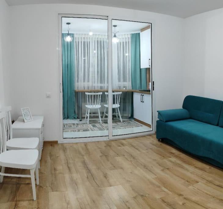 a living room with a blue couch and a table at Apartament in Ialoveni la 5 km de Chisinau in Ialoveni