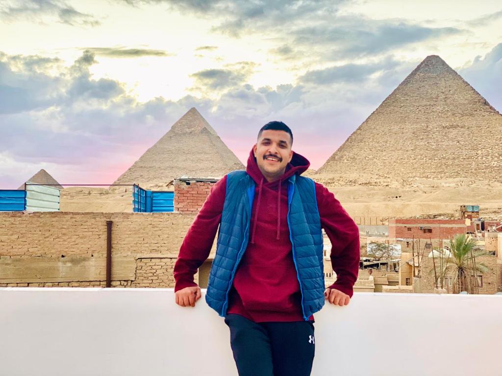 a man standing in front of the pyramids at Horus pyramids view in Cairo