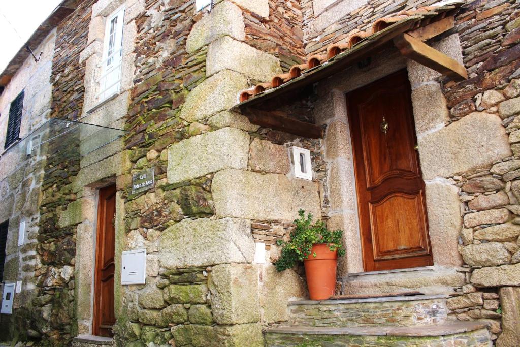 a stone building with a door and a potted plant at Casa Retiro de Xisto in Videmonte