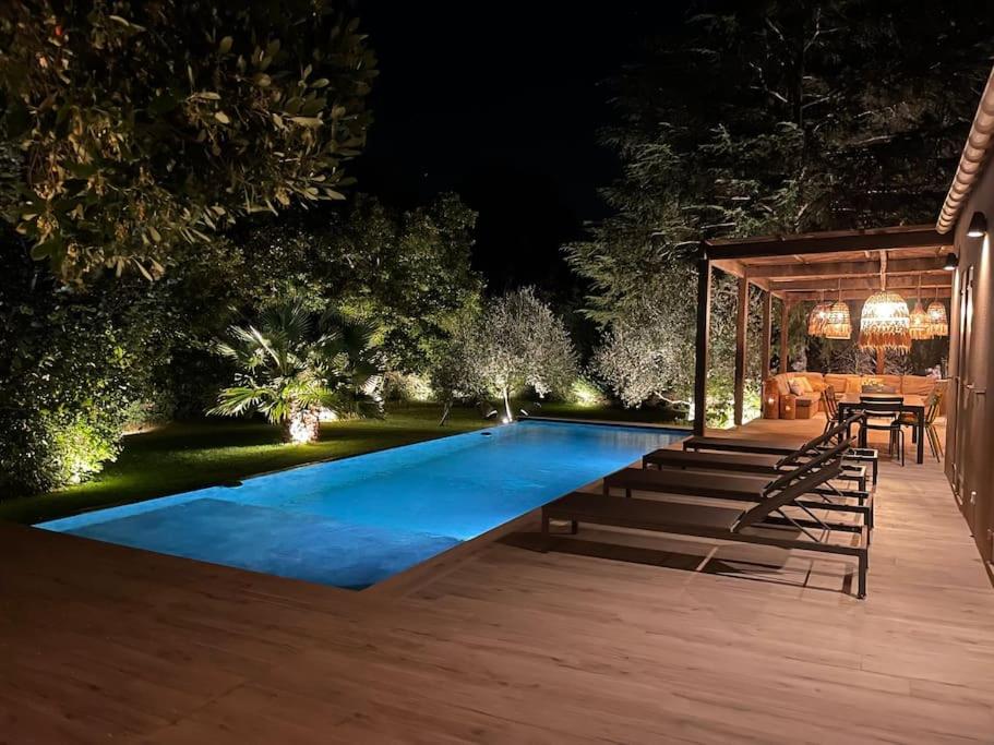 une piscine dans un jardin la nuit dans l'établissement Un paradis avec piscine au cœur du village, à Cassis
