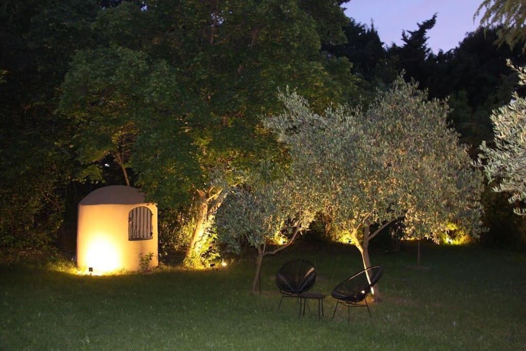 two chairs and a building in a field at night at Un paradis avec piscine au cœur du village in Cassis