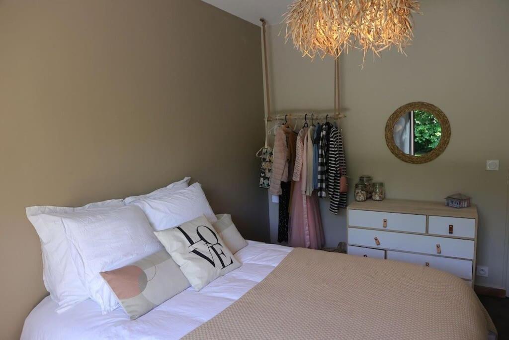 a bedroom with a bed with white sheets and a chandelier at Un paradis avec piscine au cœur du village in Cassis
