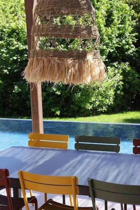 a table with two chairs and a bird cage at Un paradis avec piscine au cœur du village in Cassis