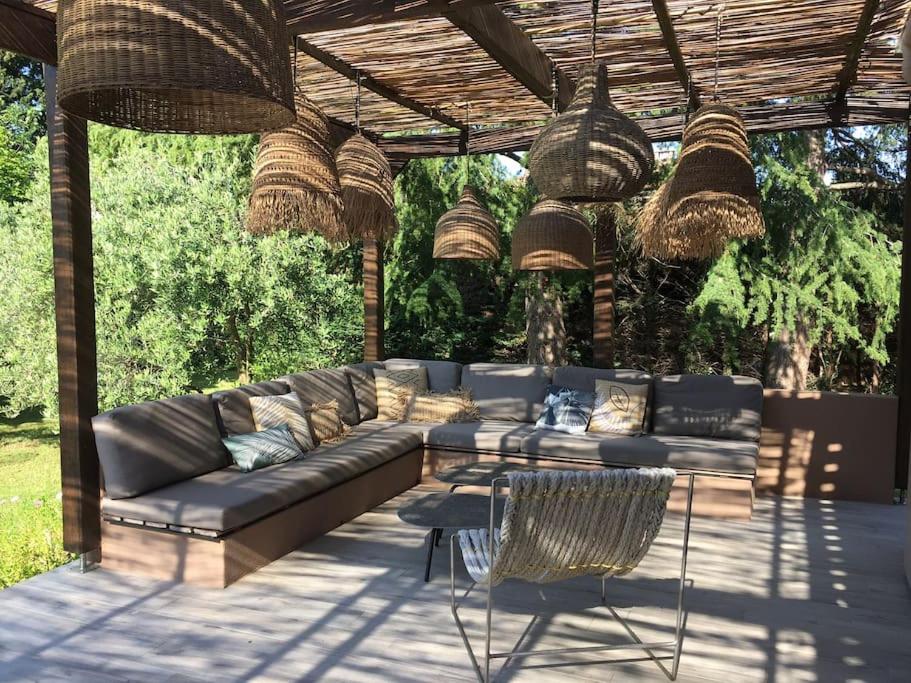 a patio with a couch and chairs under a pergola at Un paradis avec piscine au cœur du village in Cassis