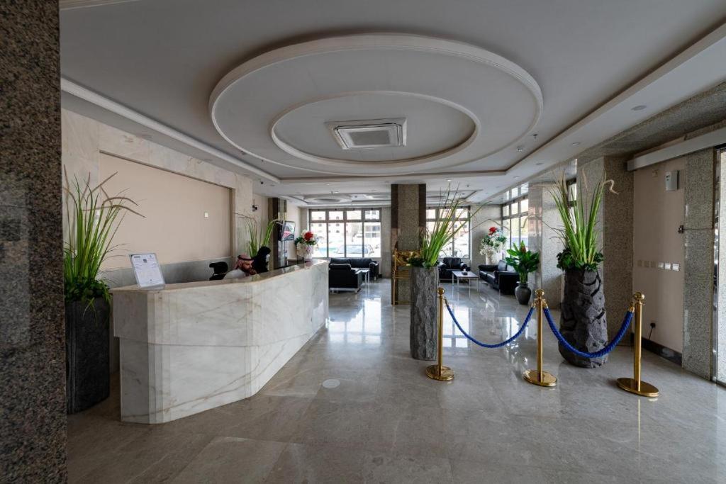 a lobby with a reception desk and plants at هوليداي بلس المروه- Holiday Plus Al Marwa in Jeddah