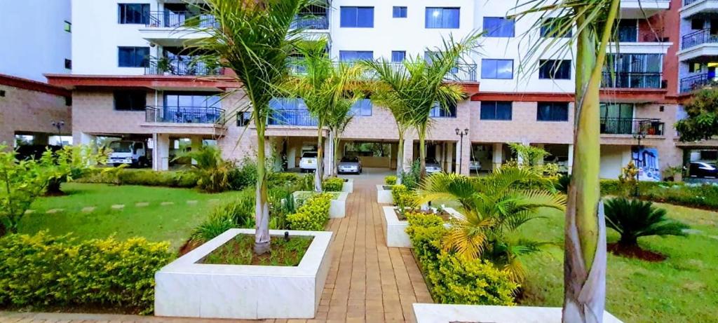 a courtyard with palm trees in front of a building at the perfect affordable apartments in Nairobi
