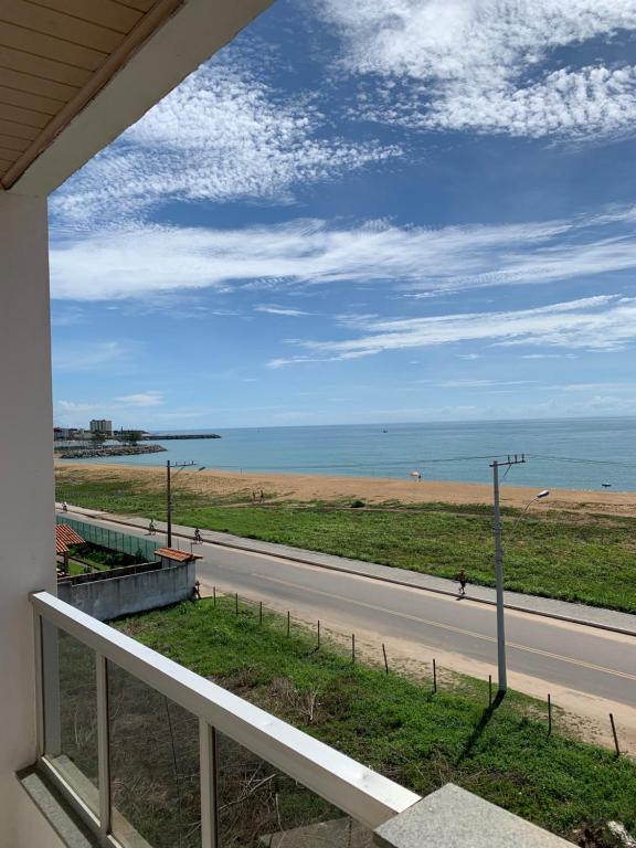 uma vista para a praia a partir da varanda de uma casa em Bela vista a beira mar em Marataizes